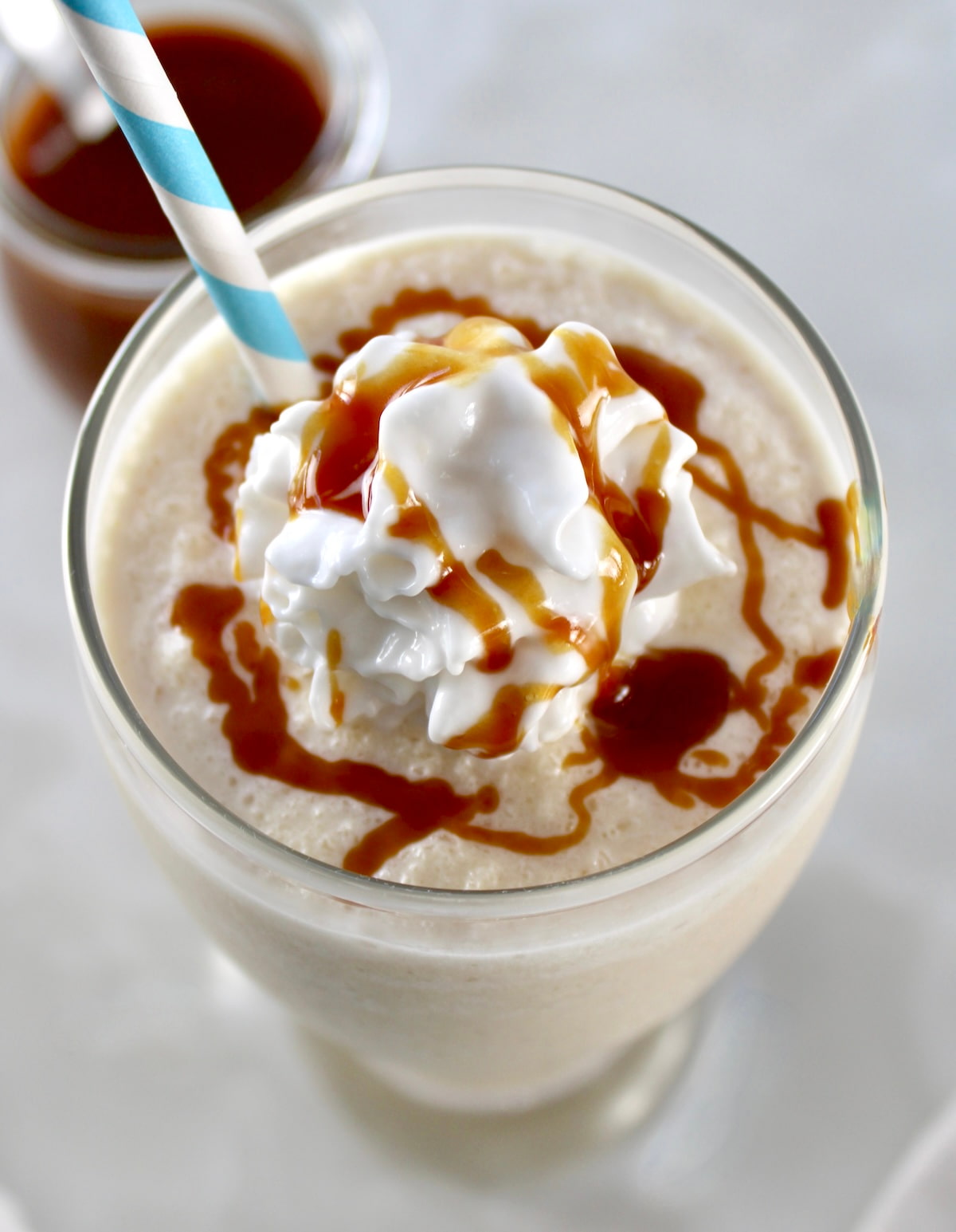 overhead view of Keto Salted Caramel Milkshake in glass with whip cream and caramel drizzled on top