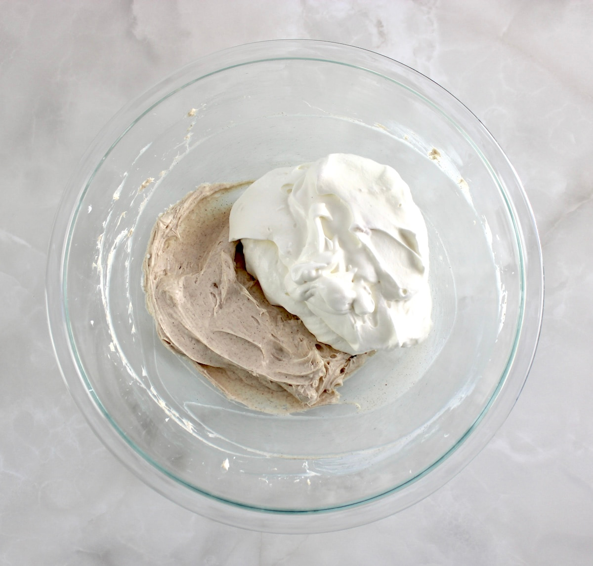snickerdoodle cheesecake fluff and whip cream in glass mixing bowl unmixed