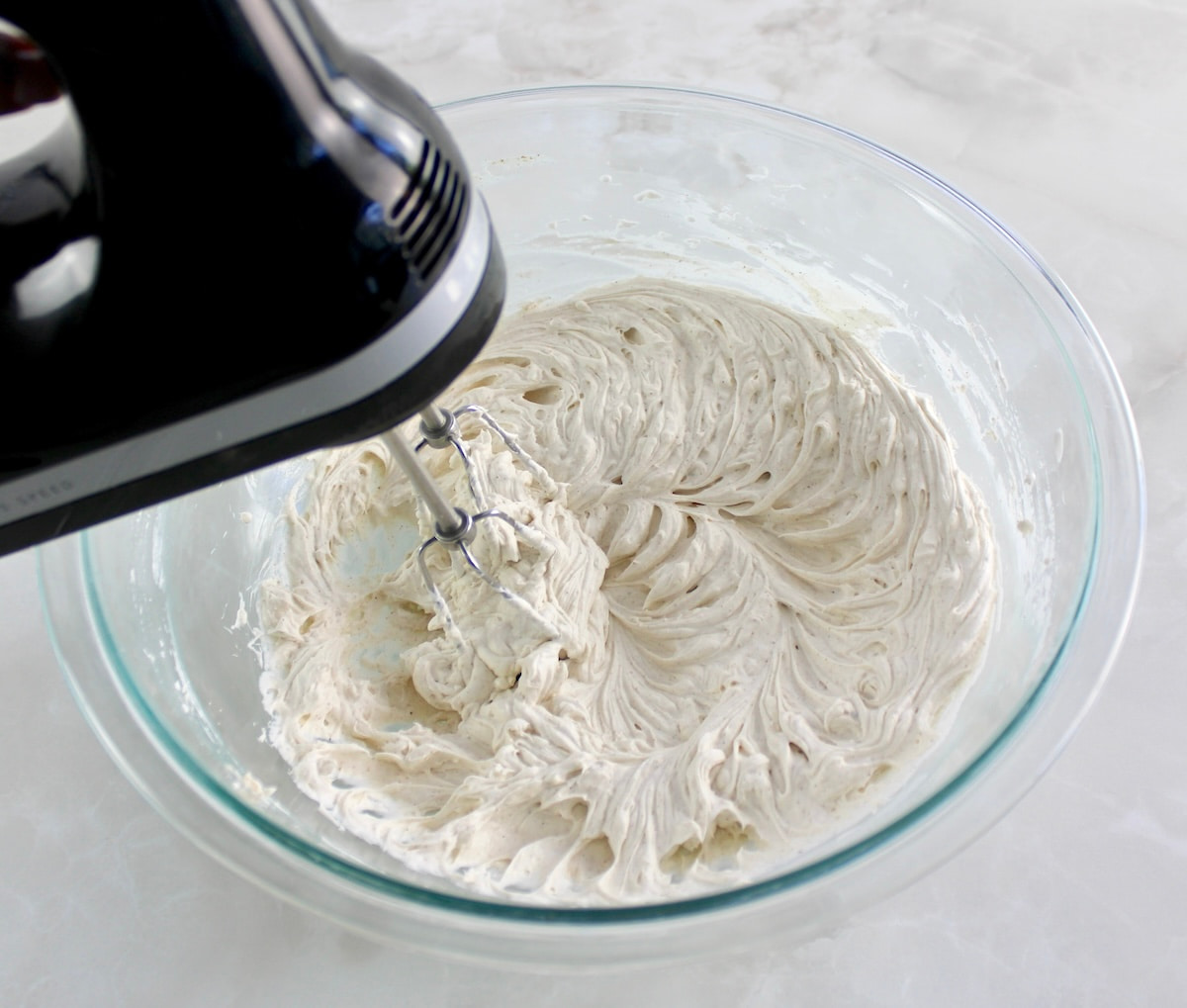 Keto Snickerdoodle Cheesecake fluff in glass bowl with hand mixer