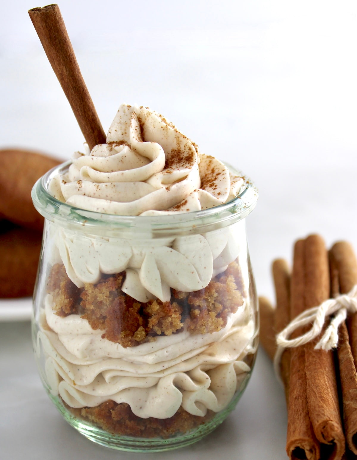 closeup side view of Keto Snickerdoodle Cheesecake Parfait in open glass jar with cinnamon stick