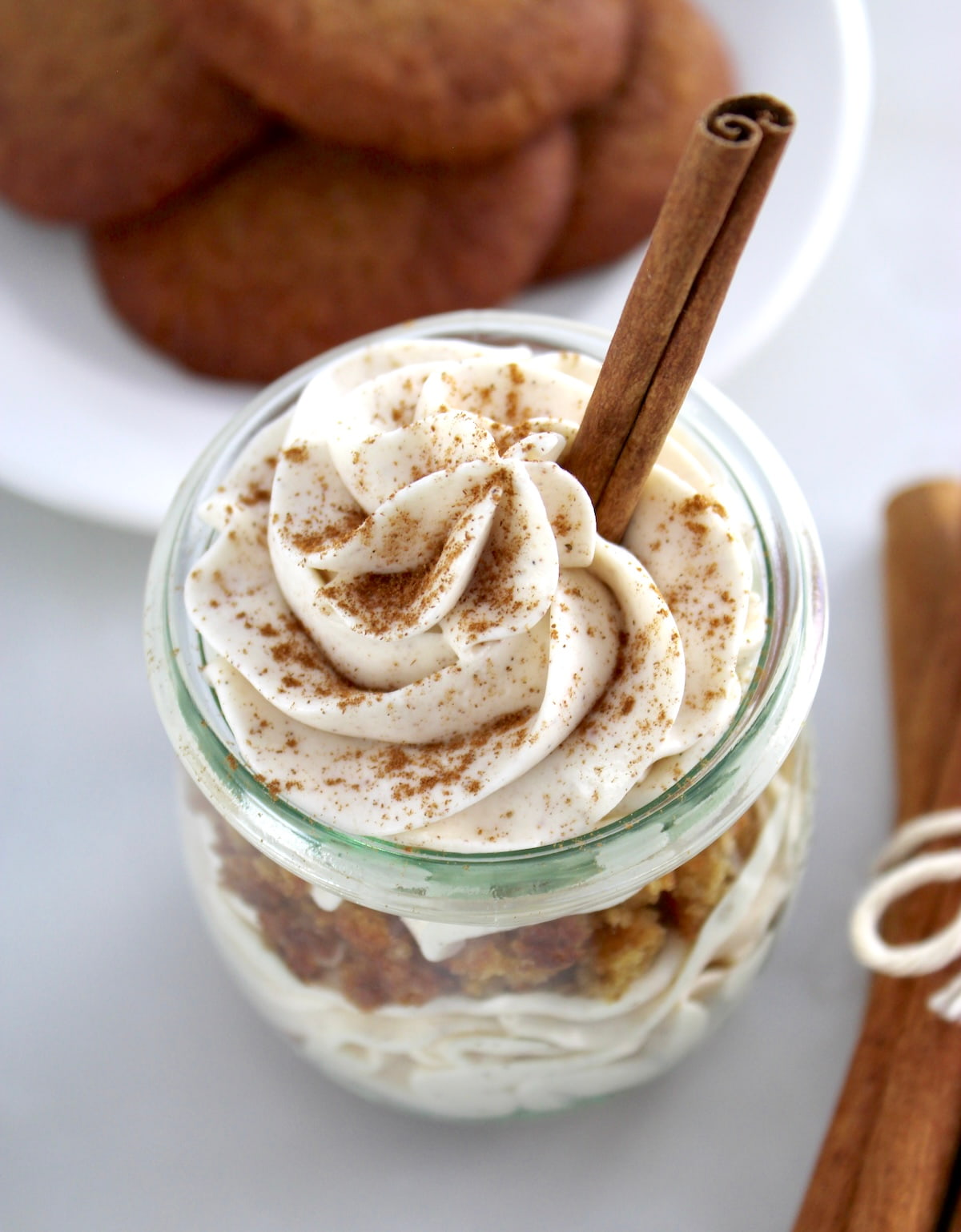 overhead view of Keto Snickerdoodle Cheesecake Parfaits in glass jar with cinnamon stick