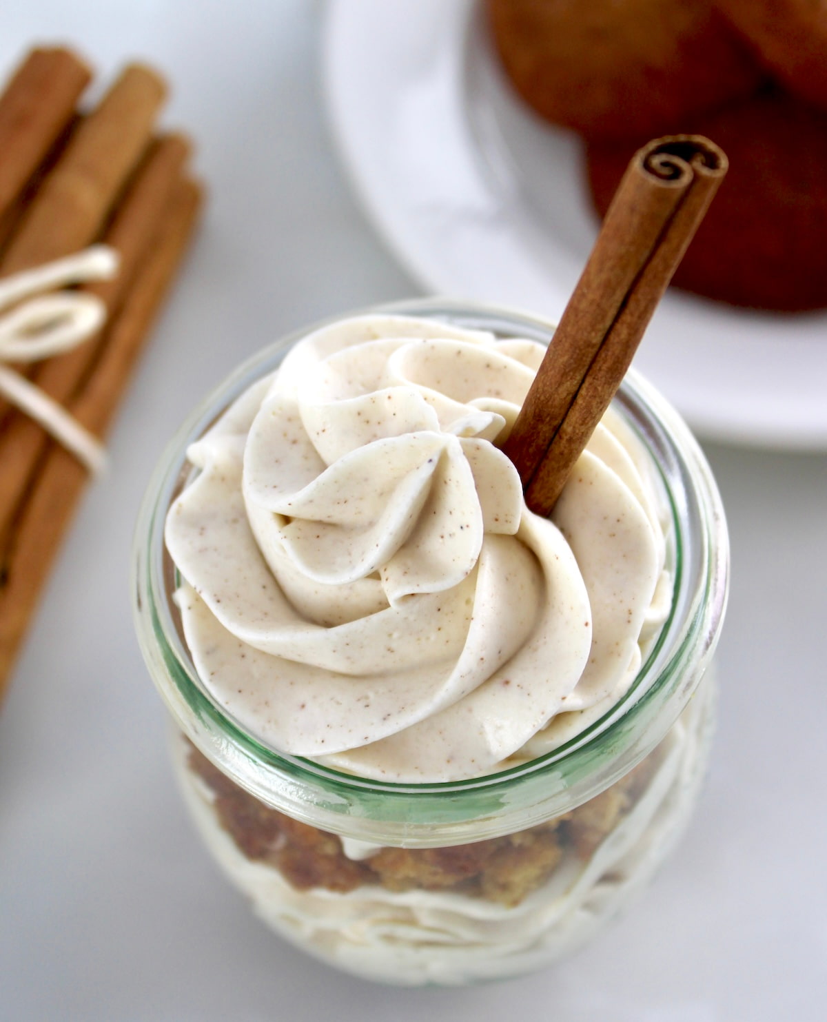 overhead view of Keto Snickerdoodle Cheesecake Parfaits in open glass jar with cinnamon stick