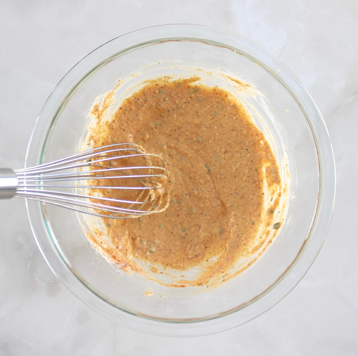 cajun stuffing mix in glass bowl with whisk