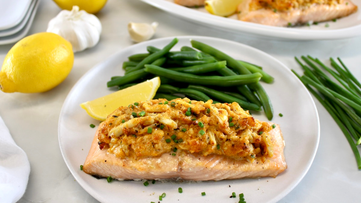 Cajun Crab Stuffed Salmon on white plate with lemon wedge and green beans