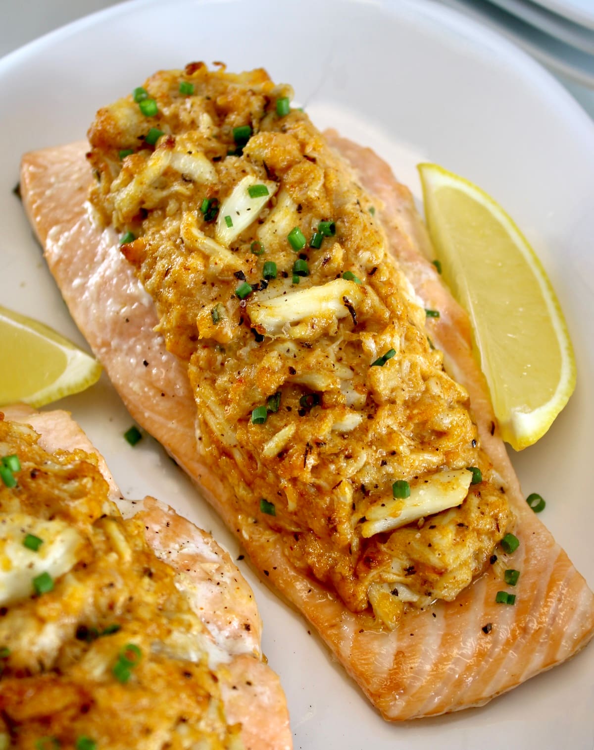 closeup of Cajun Crab Stuffed Salmon on white plate with lemon wedges