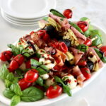 Italian Antipasti Skewers on white oval plate with balsamic glaze