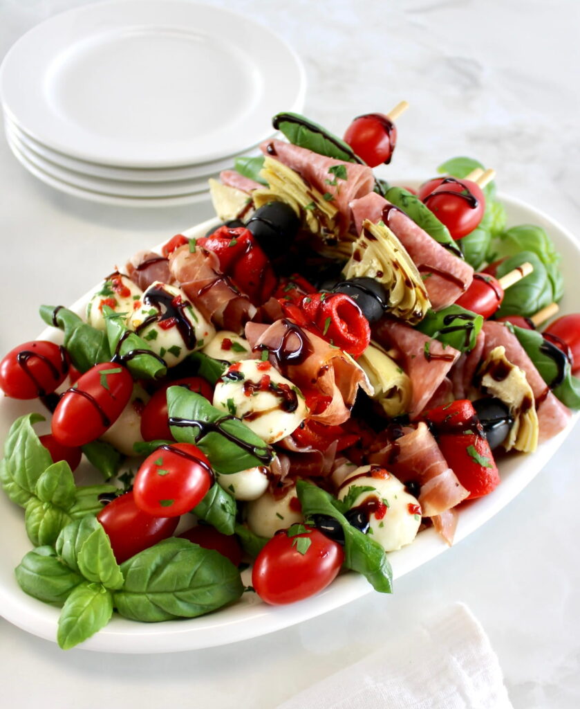 Italian Antipasti Skewers on white oval plate with balsamic glaze