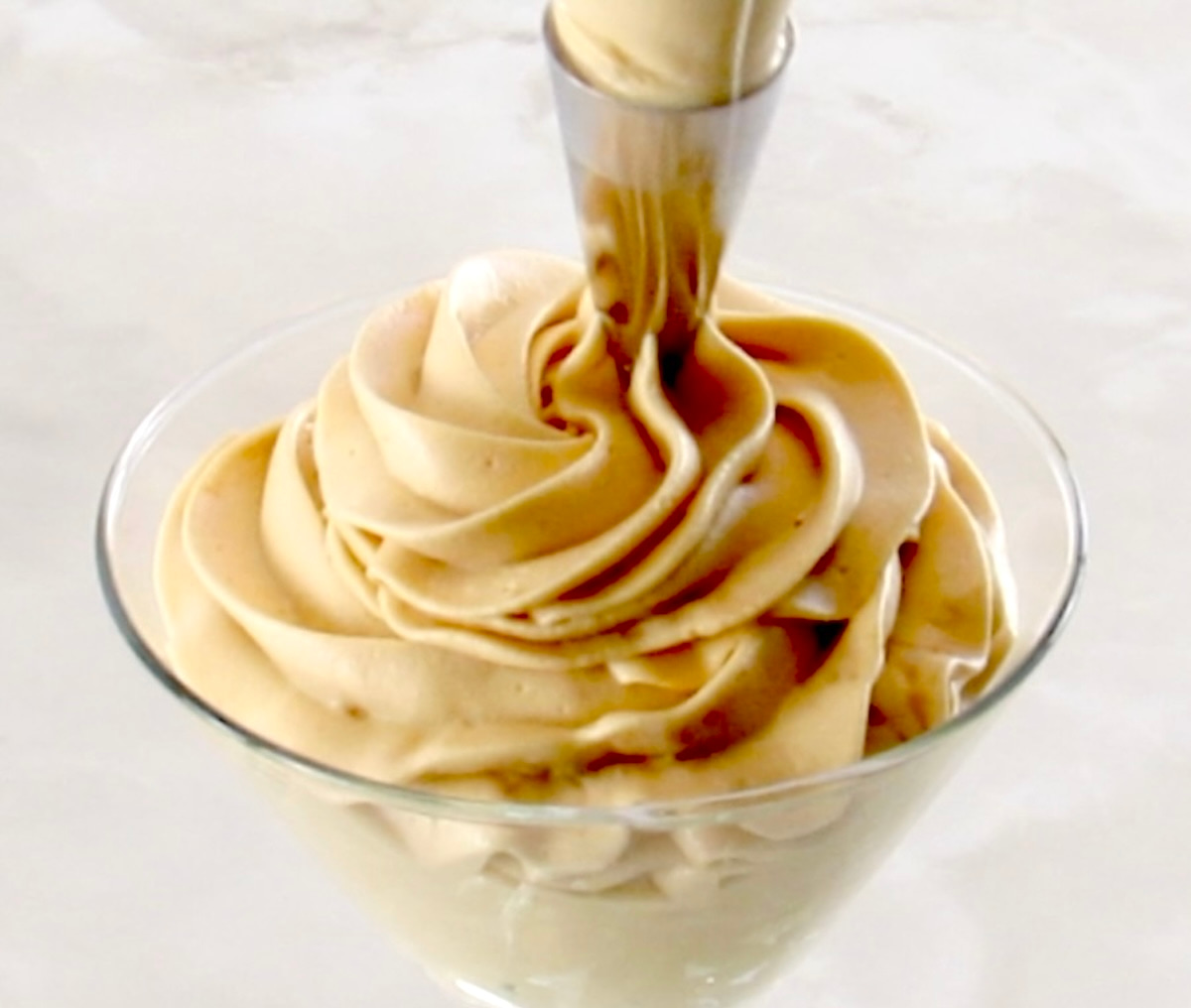 piping out Keto Salted Caramel Cheesecake Mousse into glass