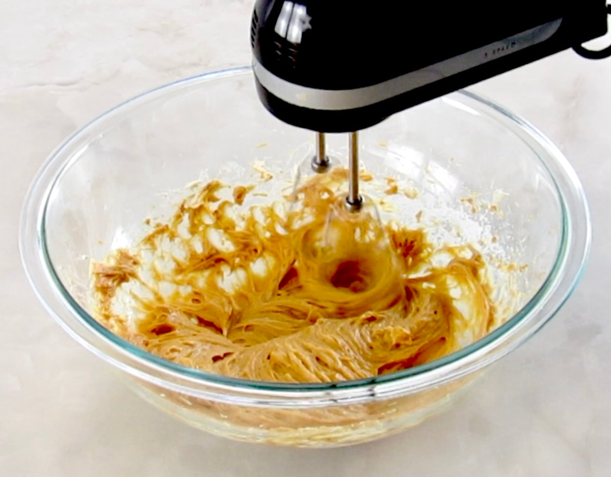  Keto Salted Caramel Cheesecake Mousse being mixed with hand mixer in glass bowl