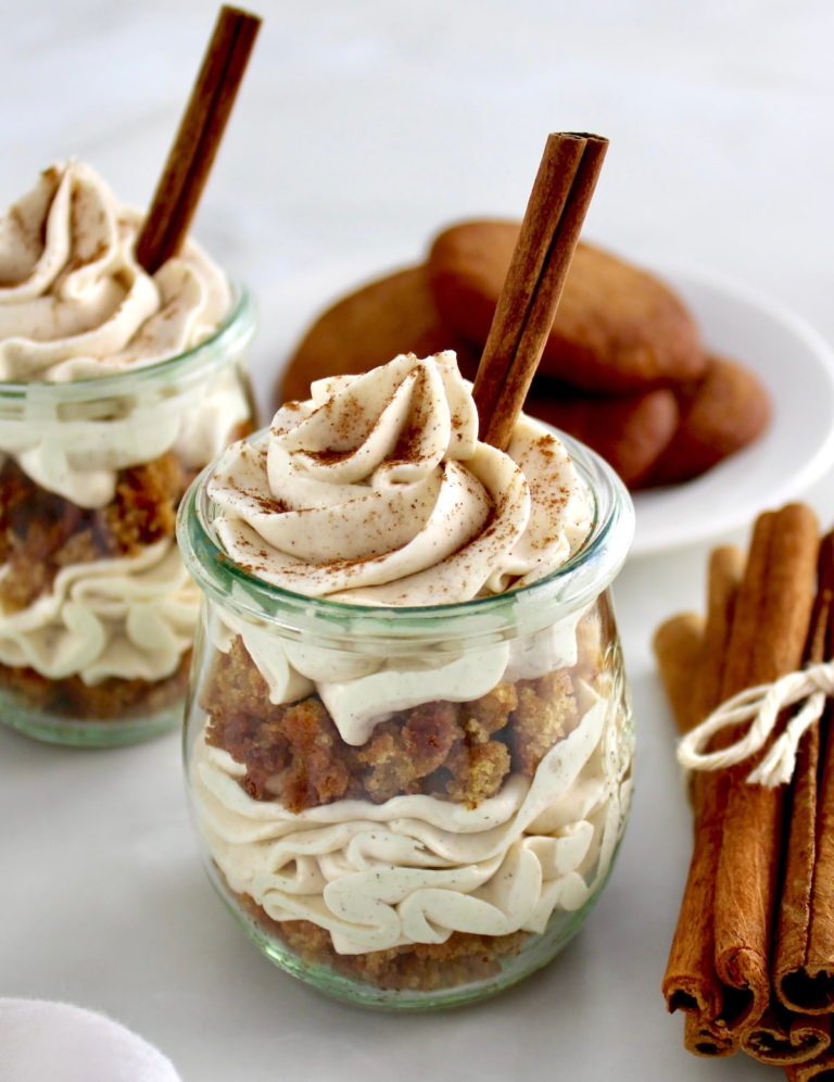 Keto Snickerdoodle Cheesecake Parfaits in open glass jars with cinnamon stick on top and on side