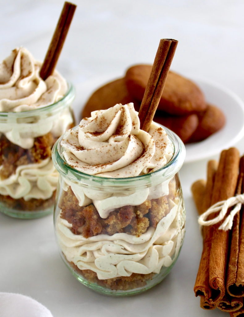 Keto Snickerdoodle Cheesecake Parfaits in open glass jars with cinnamon stick on top and on side