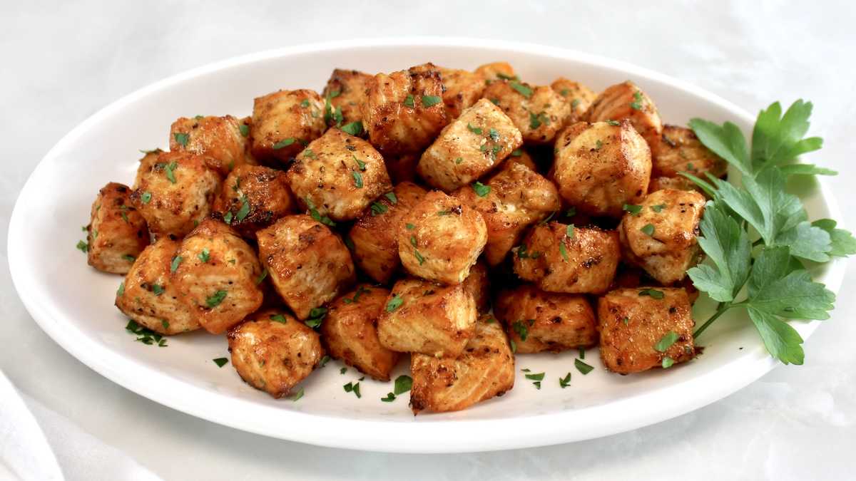 Cajun Salmon Bites on white oval plate with fresh parsley