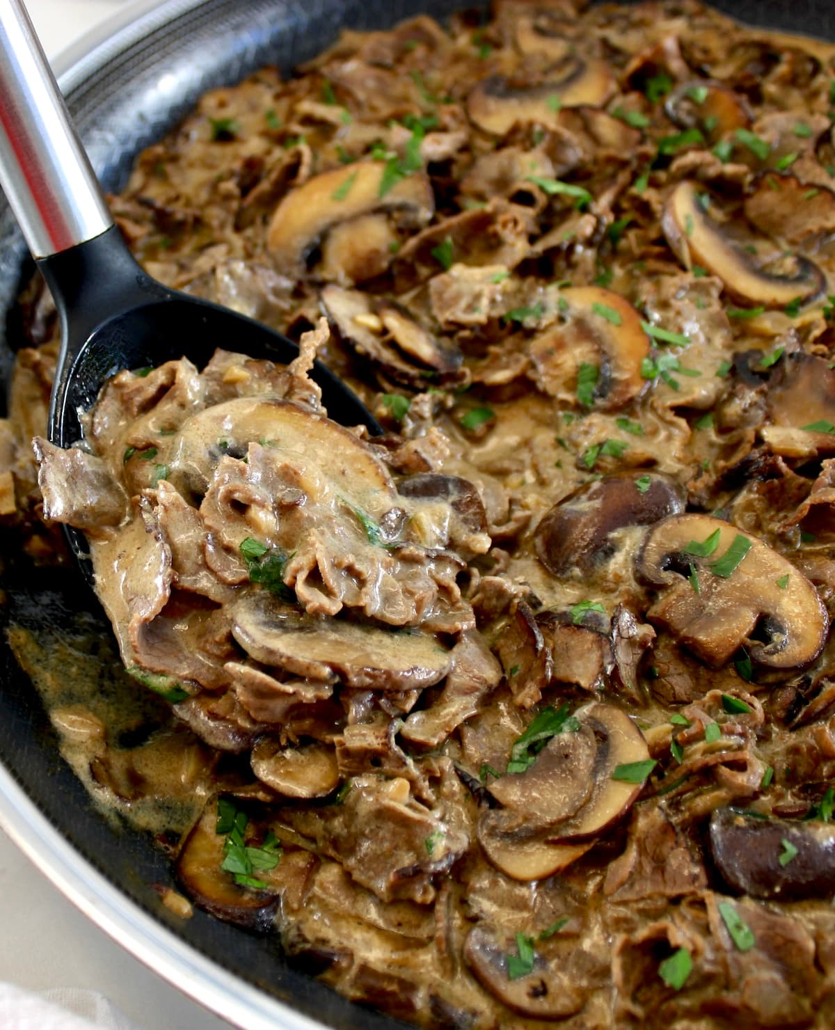 closeup of Easy Beef Stroganoff with black serving spoon scooping up some
