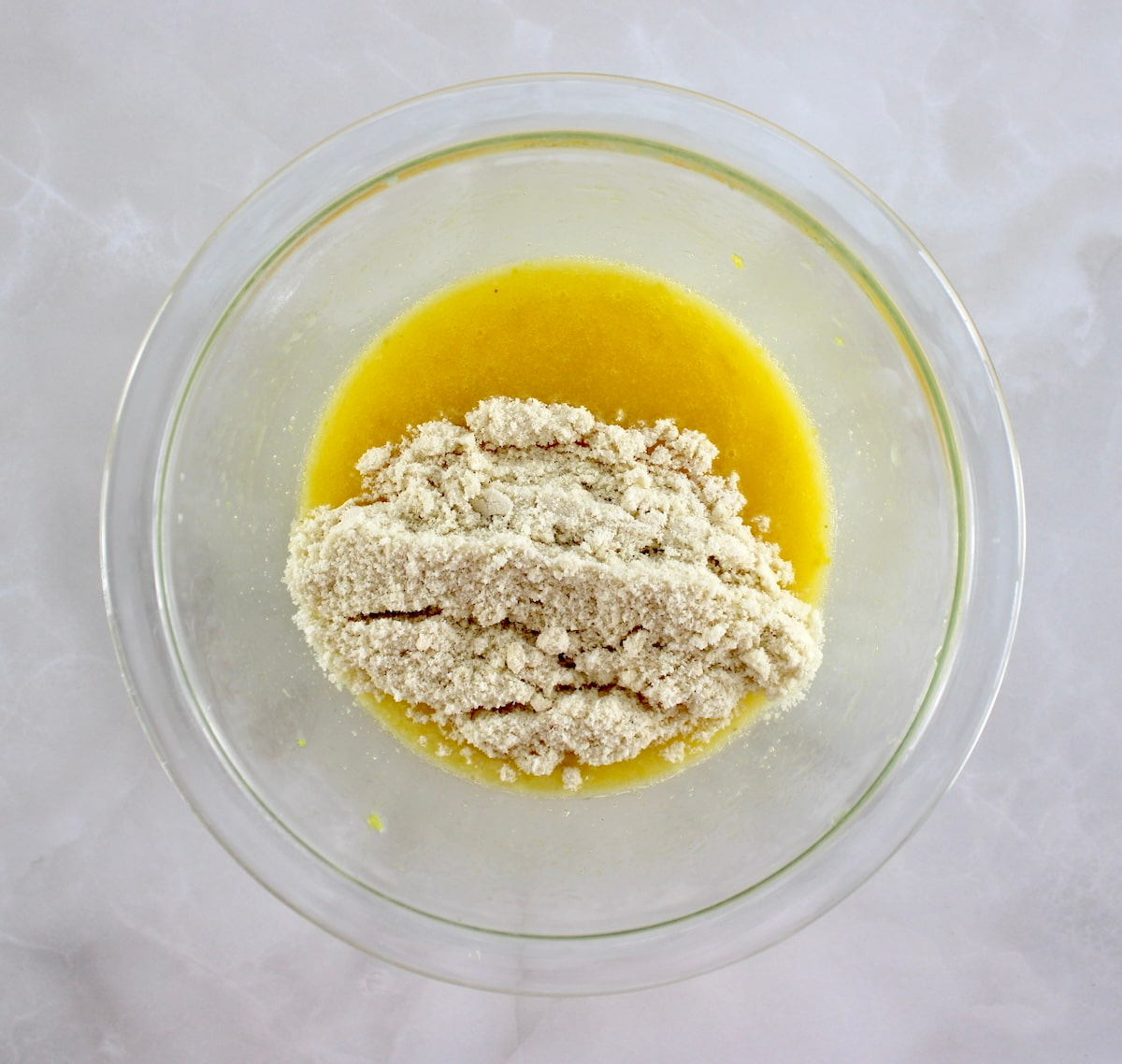 wet and dry ingredients for Keto Lemon Mug Cake in glass bowl unmixed