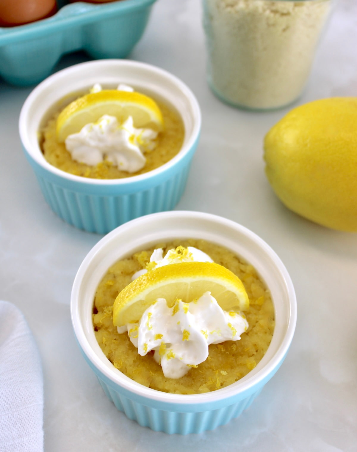 overhead view of 2 Keto Lemon Mug Cakes in blue ramekins