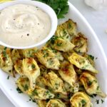 Air Fryer Artichoke Hearts on white platter with garlic aioli