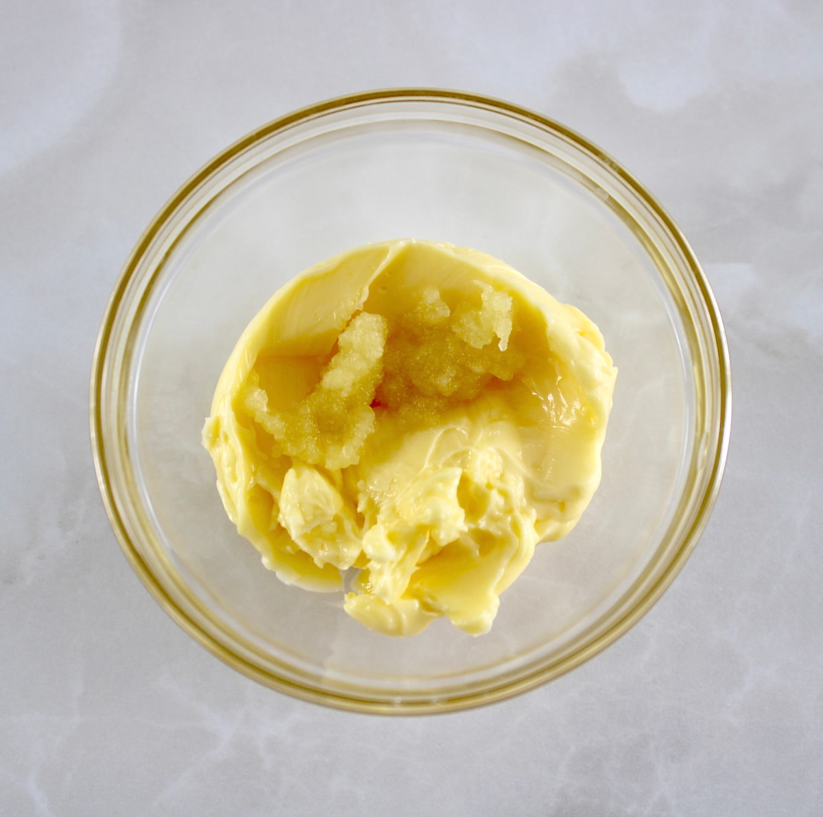butter and grated garlic in glass bowl
