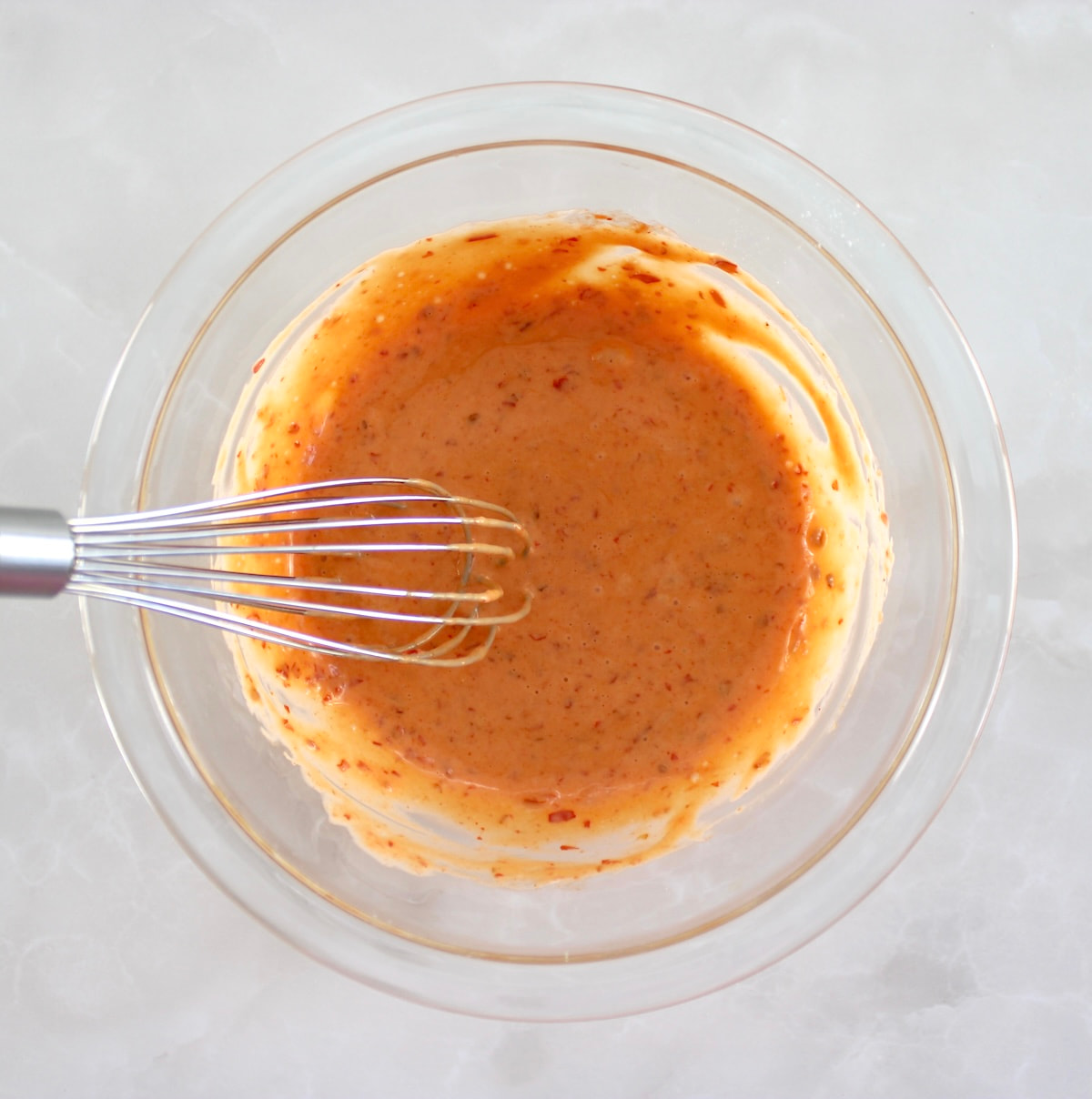 Bang Bang Sauce in glass bowl with whisk