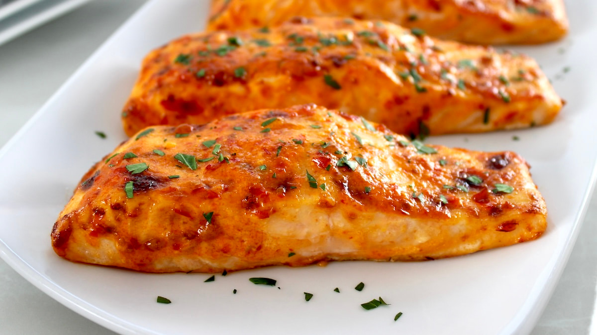 Bang Bang Salmon on white plate with chopped parsley