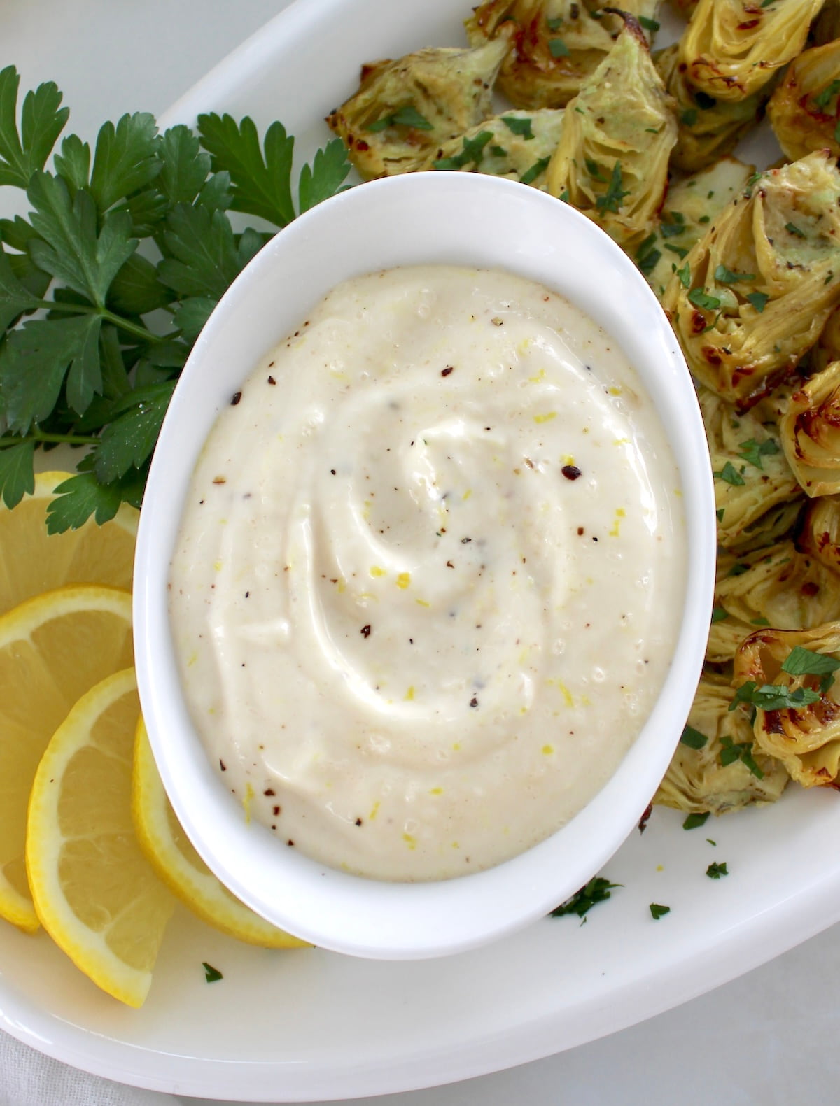Easy Garlic Aioli in white bowl with lemon on side
