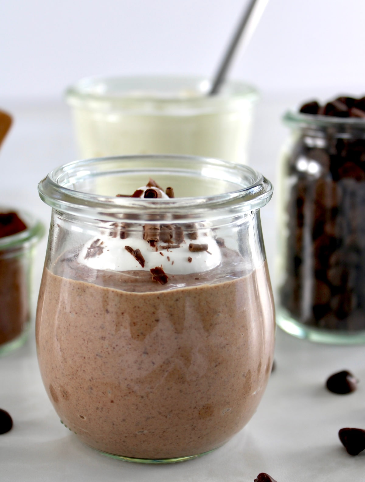 closeup side view of Ricotta Chocolate Mousse in open glass jar with whip cream