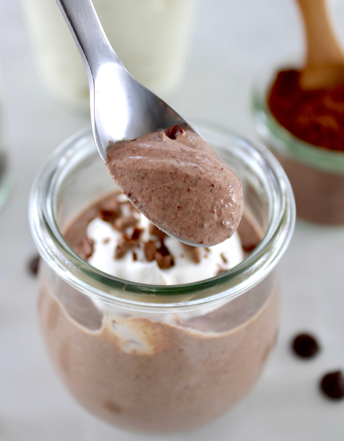 holding up spoonful of Ricotta Chocolate Mousse from open glass jar