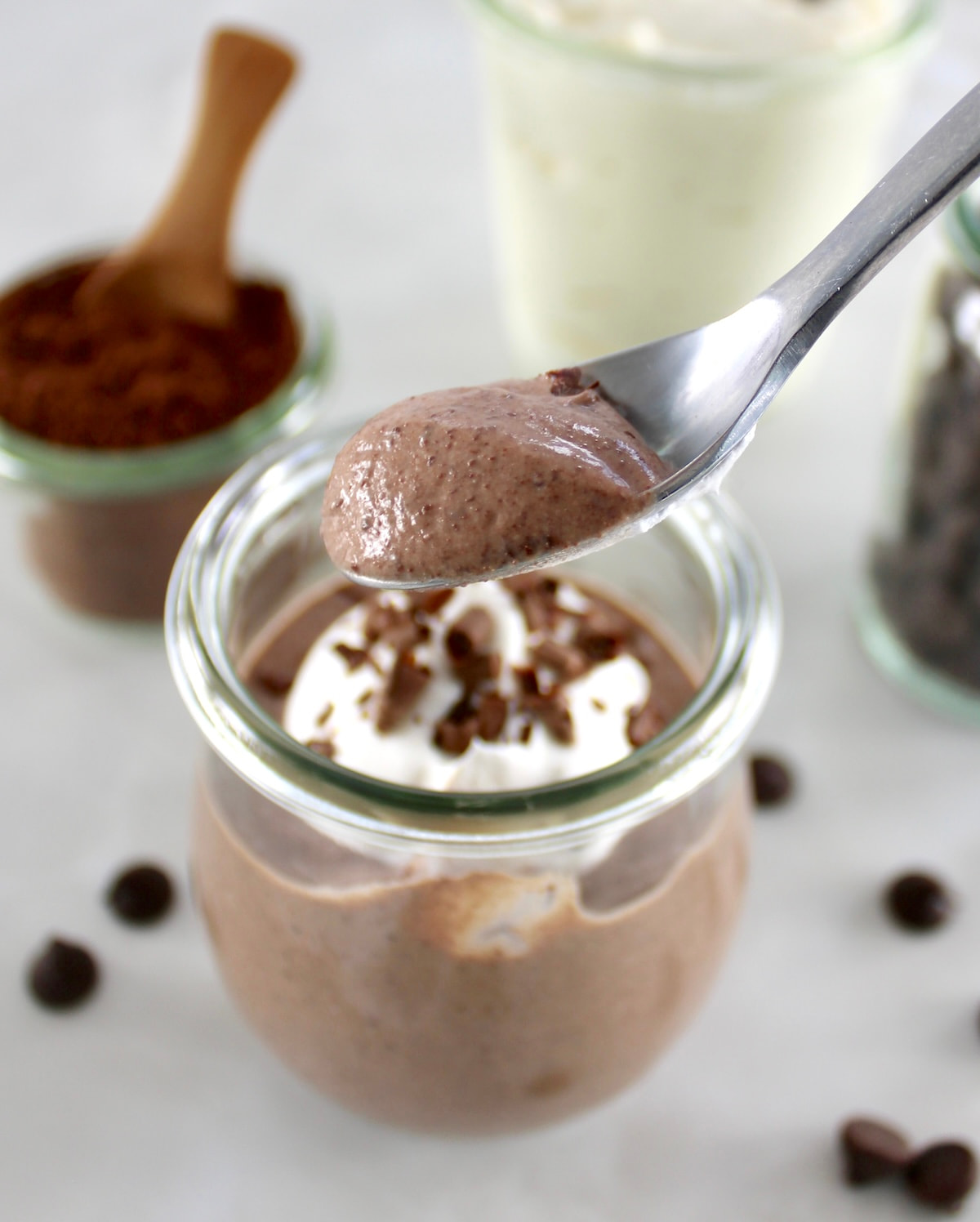 holding up spoonful of Ricotta Chocolate Mousse over open glass jar