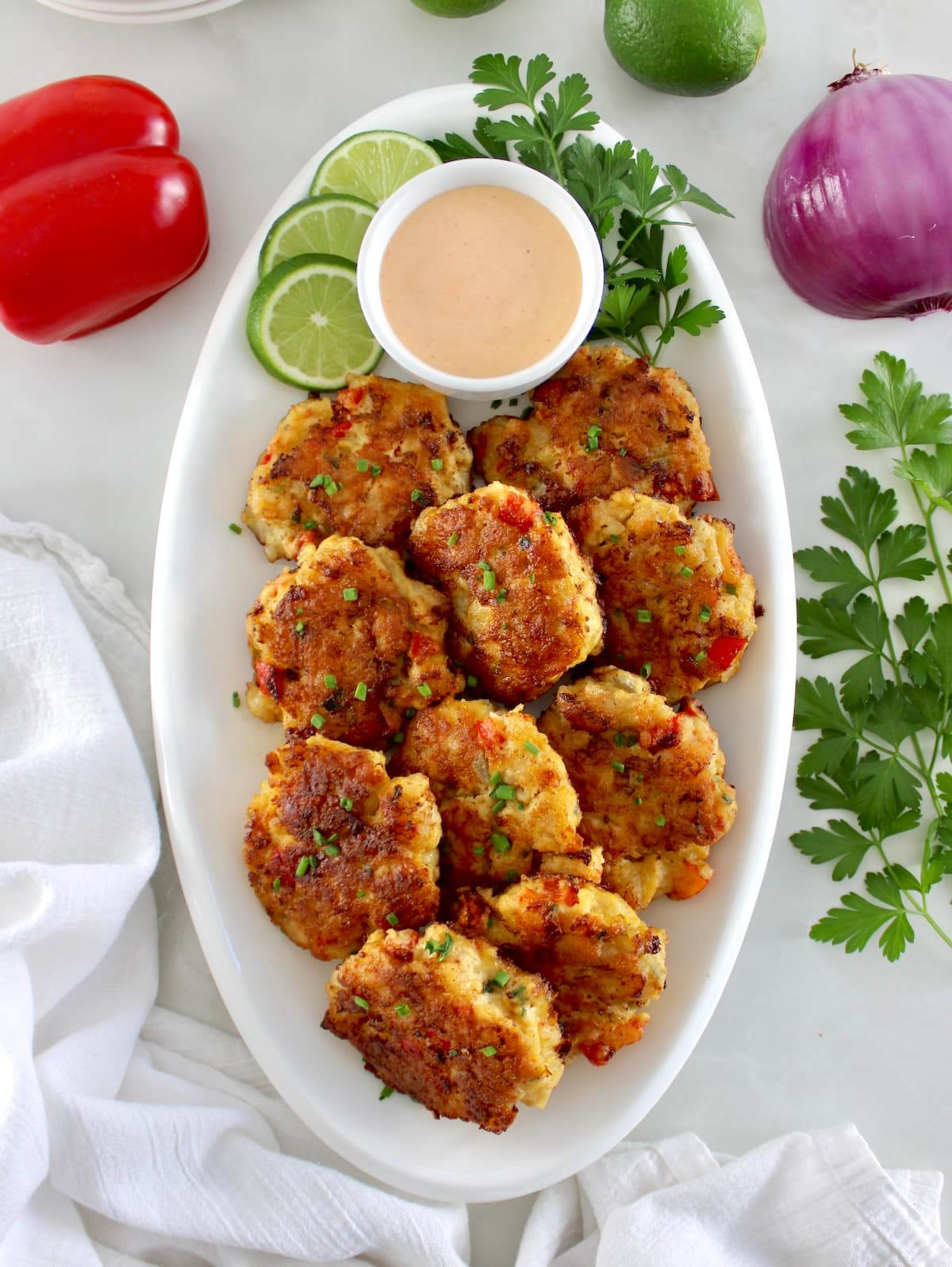 overhead view of Shrimp Cakes with Spicy Mayo on white oval platter