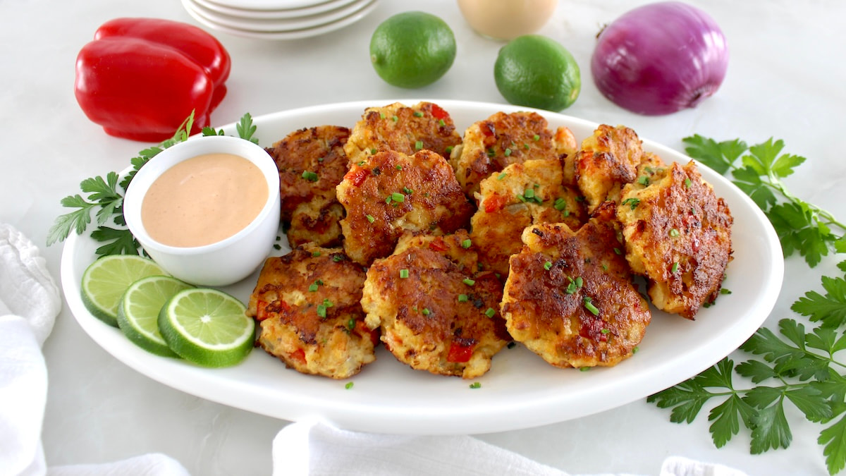 Shrimp Cakes with Spicy Mayo in white cup on white oval platter