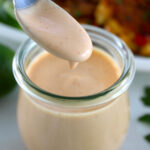 Spicy Mayo dripping off spoon in an open jar