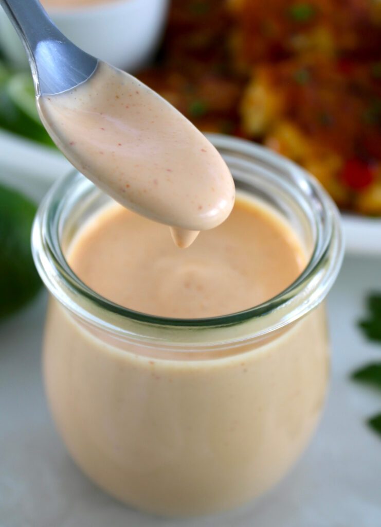Spicy Mayo dripping off spoon in an open jar
