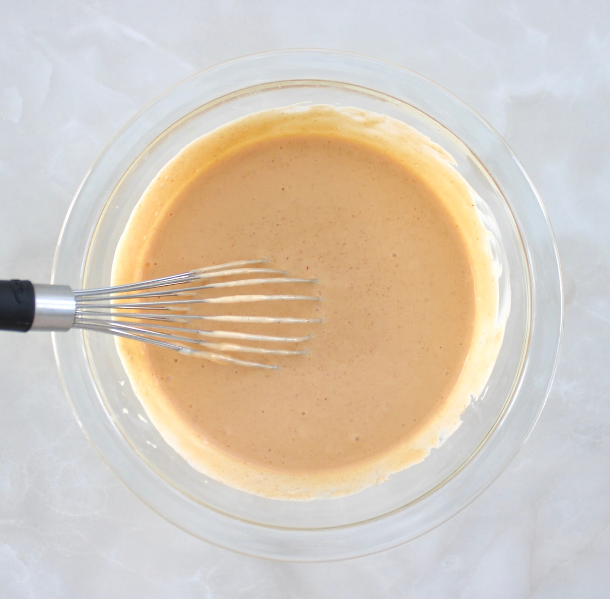 Spicy Mayo in glass bowl with whisk