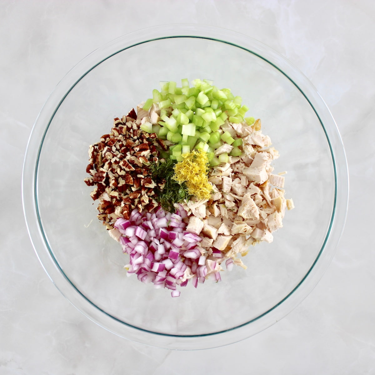 Cottage Cheese Chicken Salad ingredients in glass bowl in sections
