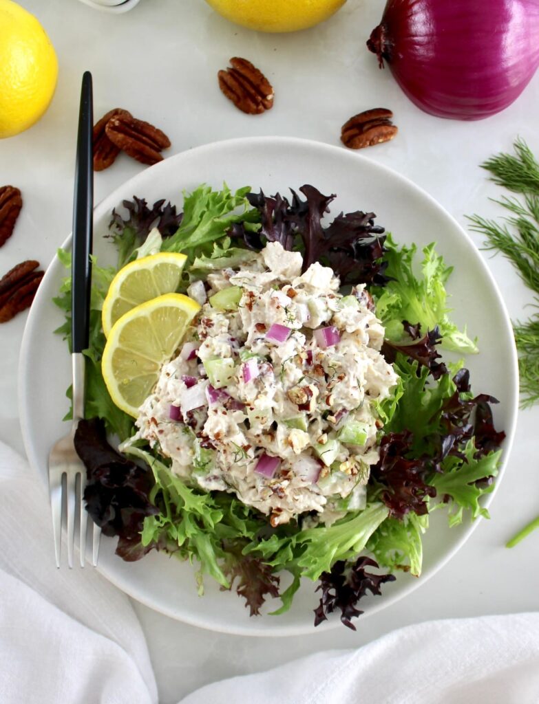 Cottage Cheese Chicken Salad over mixed greens on plate with fork on side