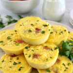 Cottage Cheese and Ham Egg Bites on white plate with chopped parsley garnish