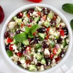 Greek Cauliflower Rice in white bowl with fresh mint garnish