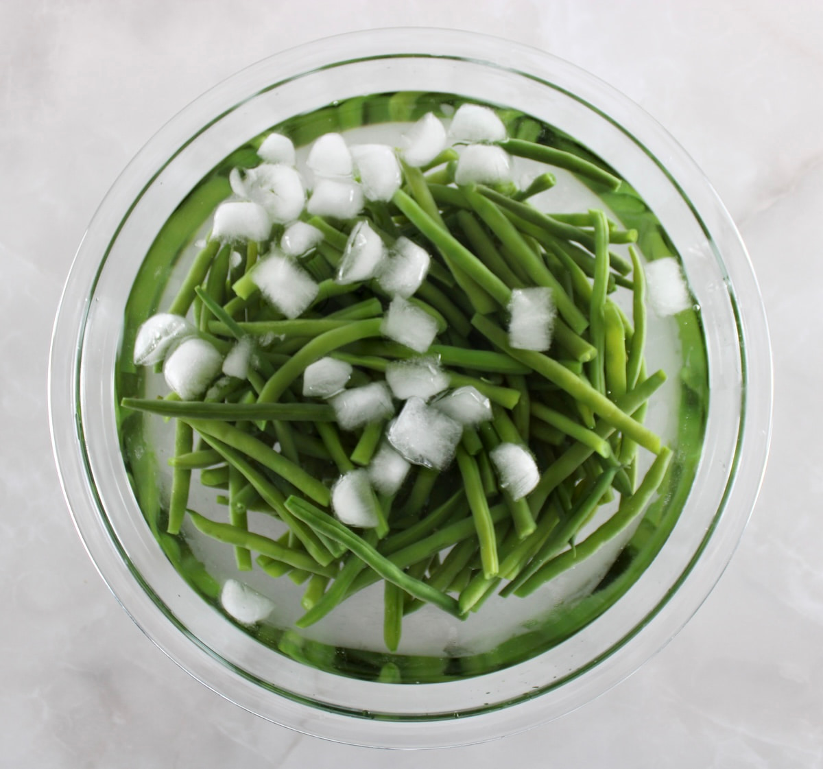 Green Beans with Mushrooms in ice water in glass bowl
