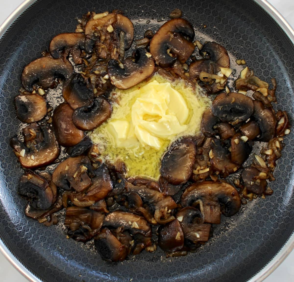 sautéed mushrooms in skillet with butter in the middle