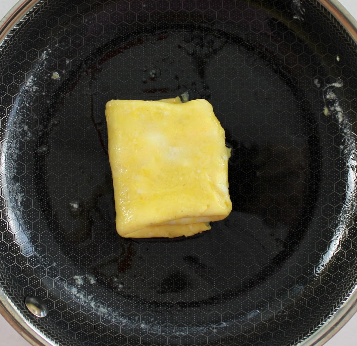 folded scrambled eggs in skillet