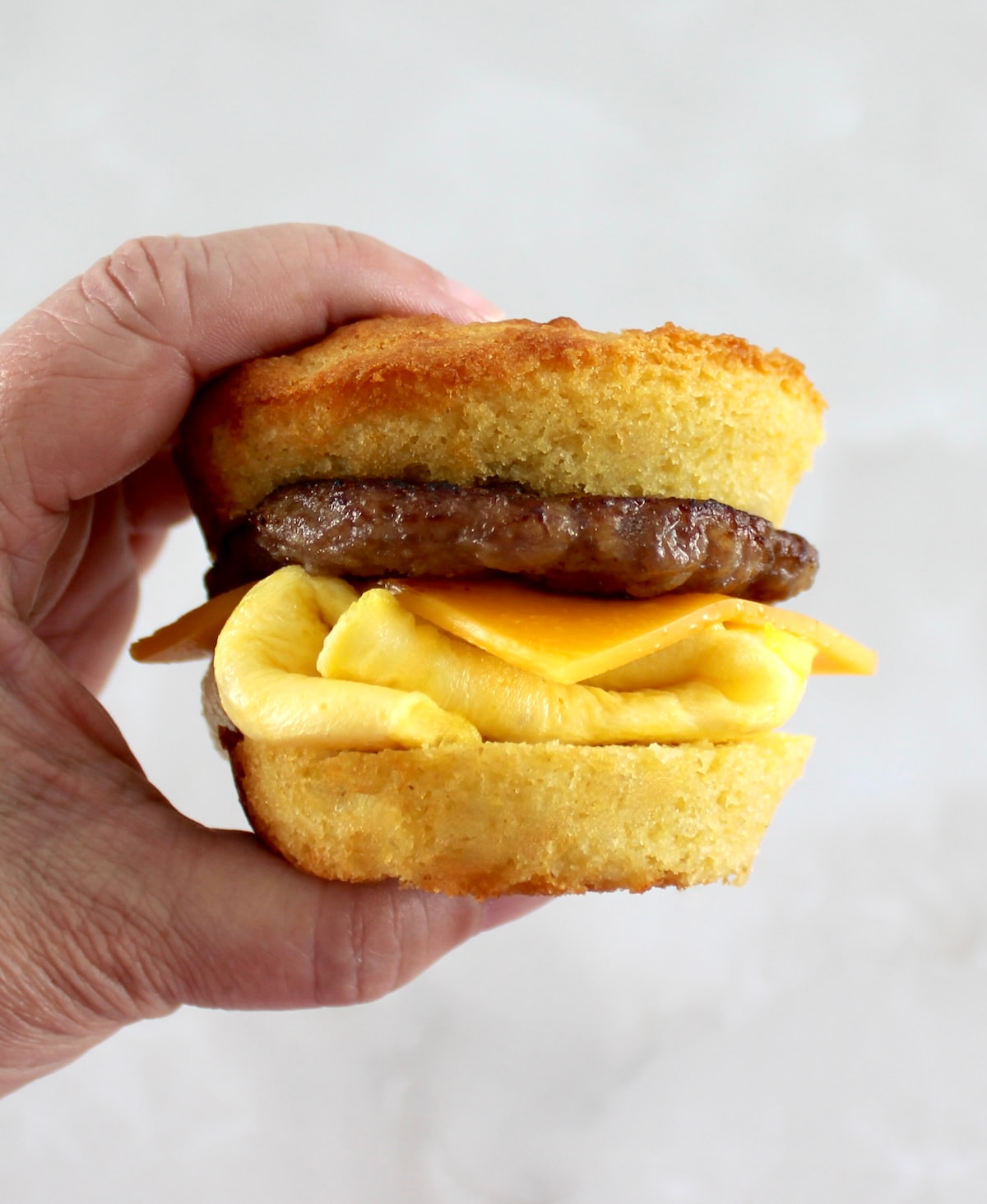 holding up Keto Sausage Egg and Cheese Biscuit