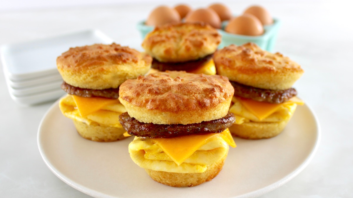 4 Keto Sausage Egg and Cheese Biscuits on white plate with eggs on back