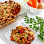 Stuffed Pepper Casserole piece on white plate with casserole in background
