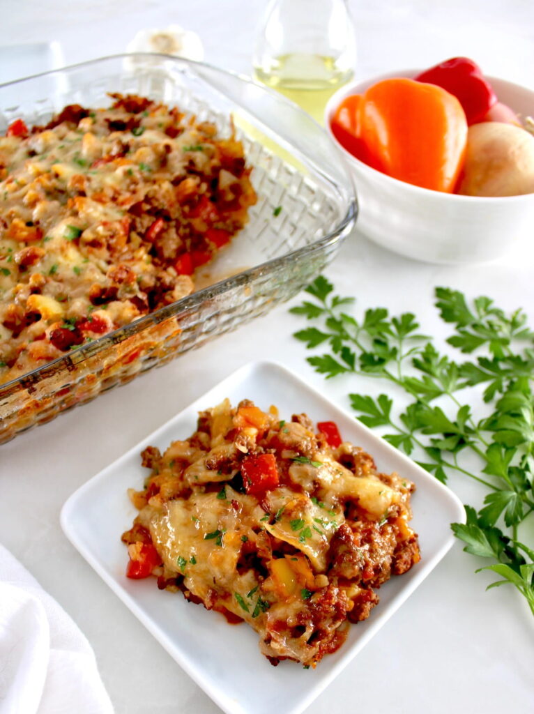 Stuffed Pepper Casserole piece on white plate with casserole in background