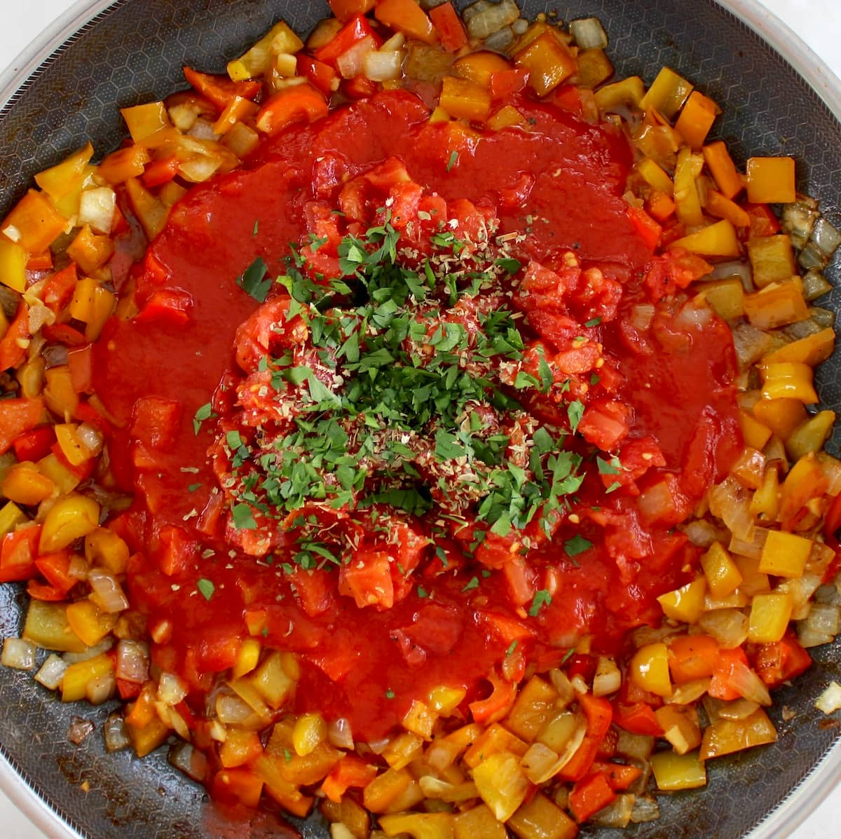 bell peppers, tomato sauce, tomatoes and parsley in skillet