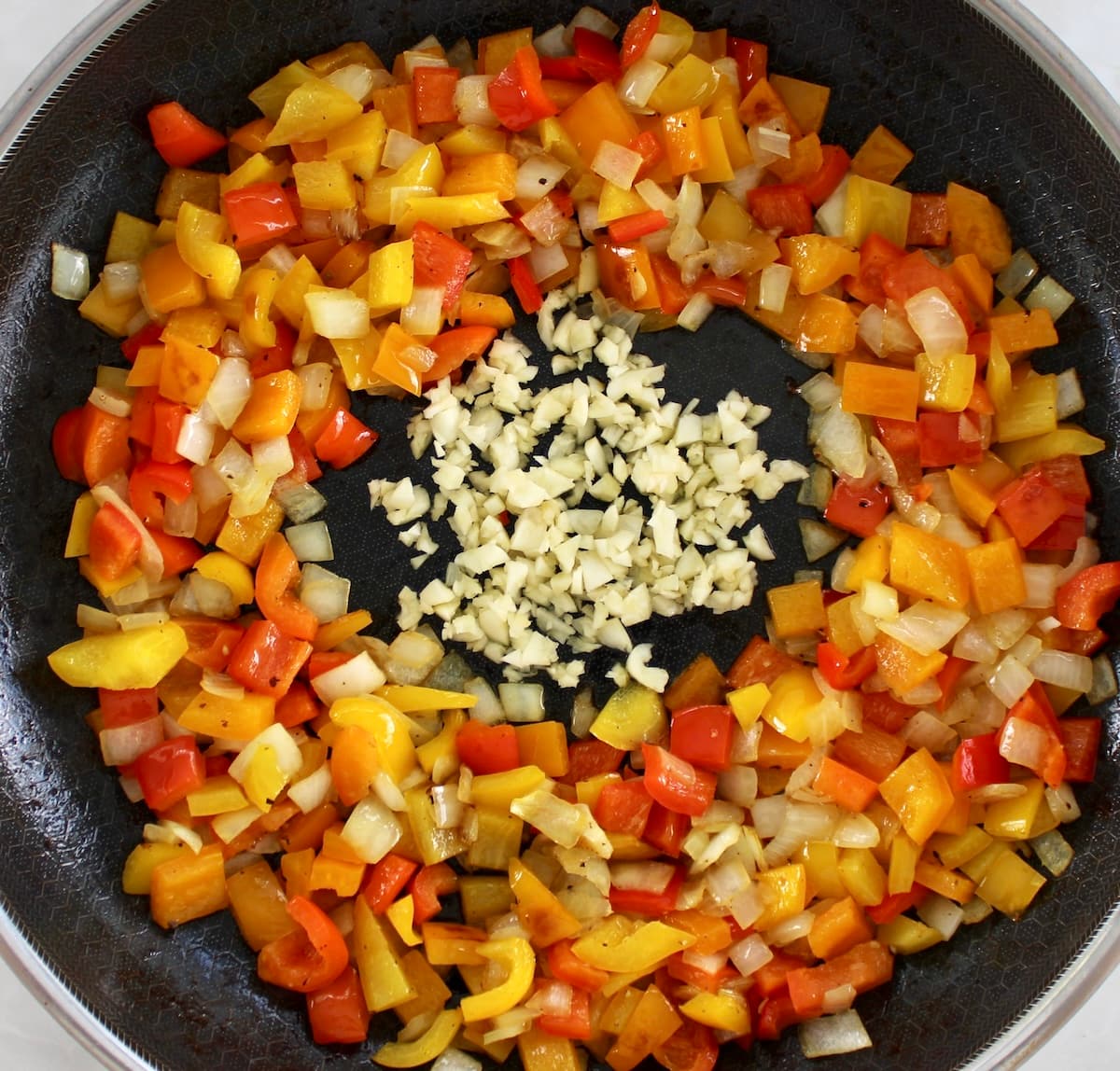bell peppers, onions and minced garlic in skillet
