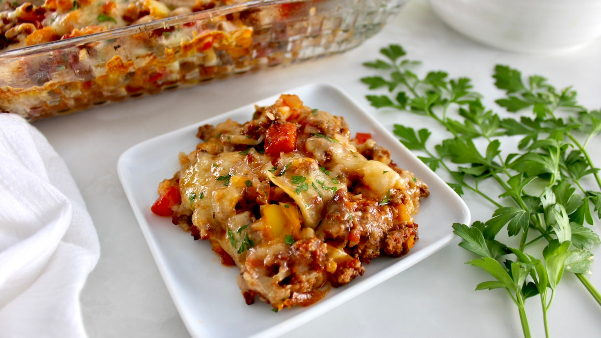 piece of Stuffed Pepper Casserole on white dish with casserole in back