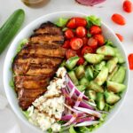 overhead view of Balsamic Grilled Chicken Salad in white bowl with sliced chicken