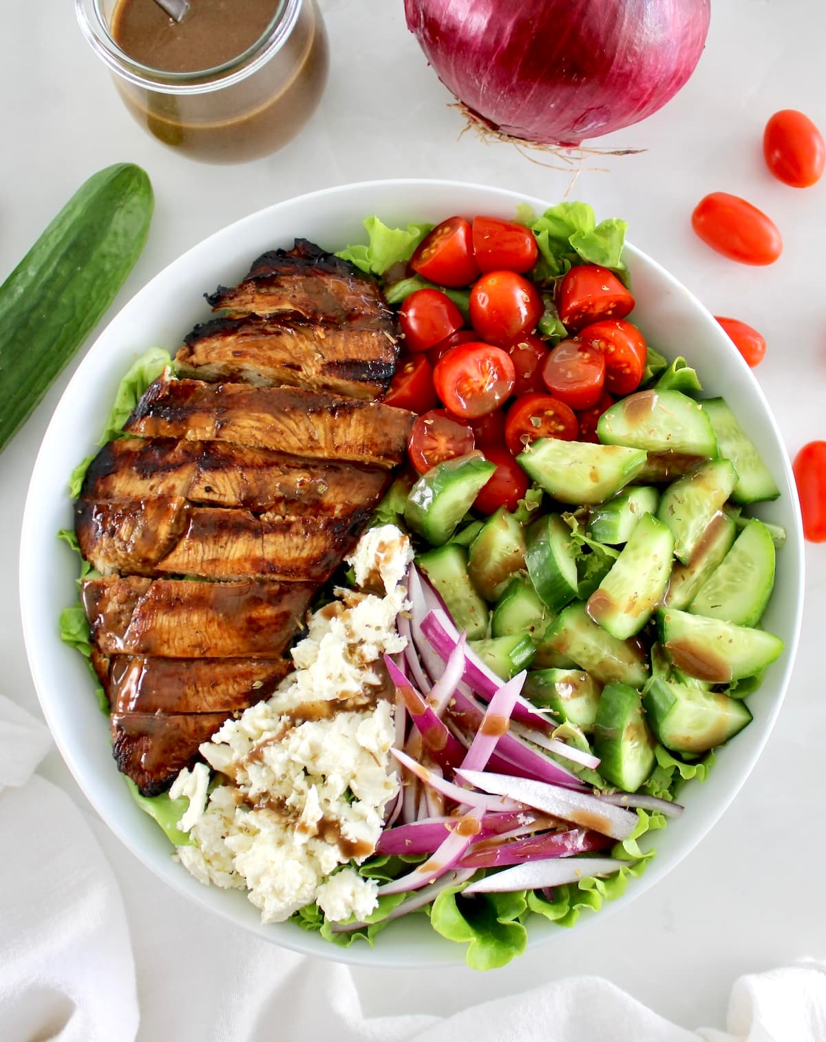 overhead view of Balsamic Grilled Chicken Salad in white bowl with sliced chicken