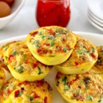 Chorizo and Pepper Egg Muffins stacked up on white plate with chopped cilantro