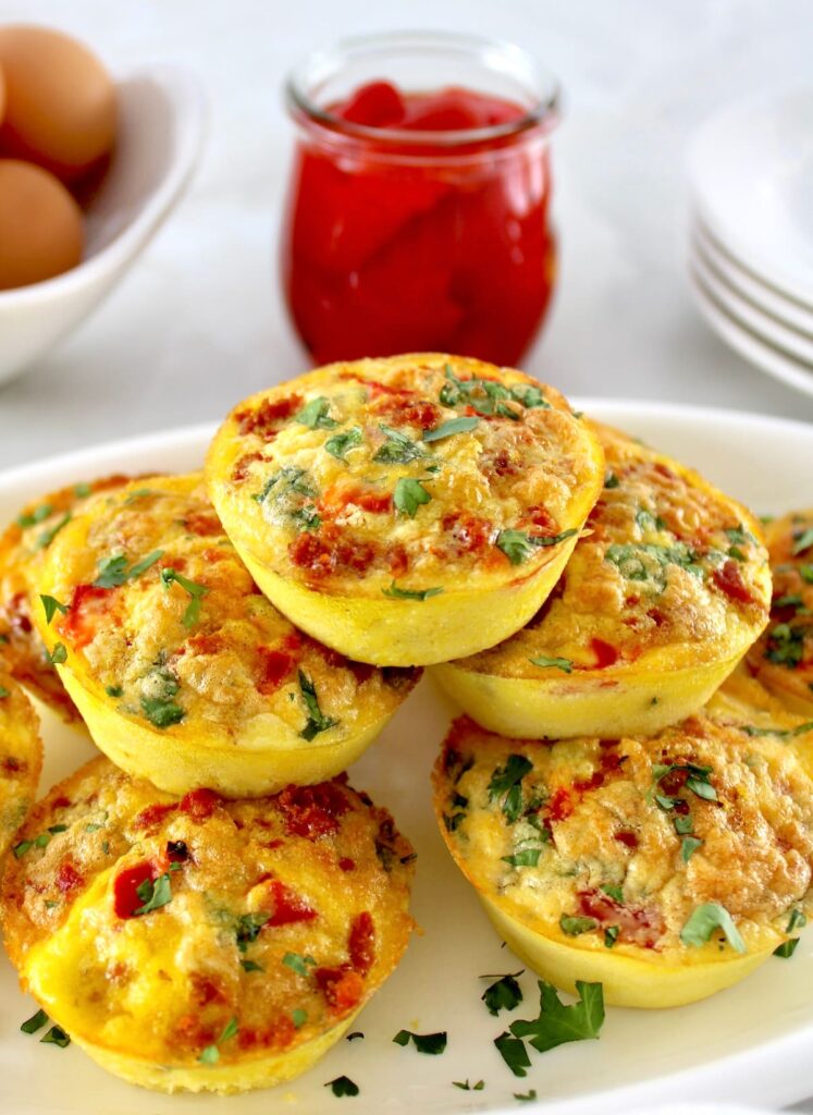 Chorizo and Pepper Egg Muffins stacked up on white plate with chopped cilantro